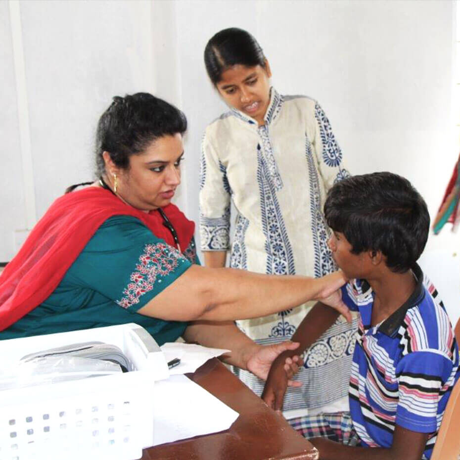 A volunteer checks the blood pressure of a patient during a medical mission trip to India.