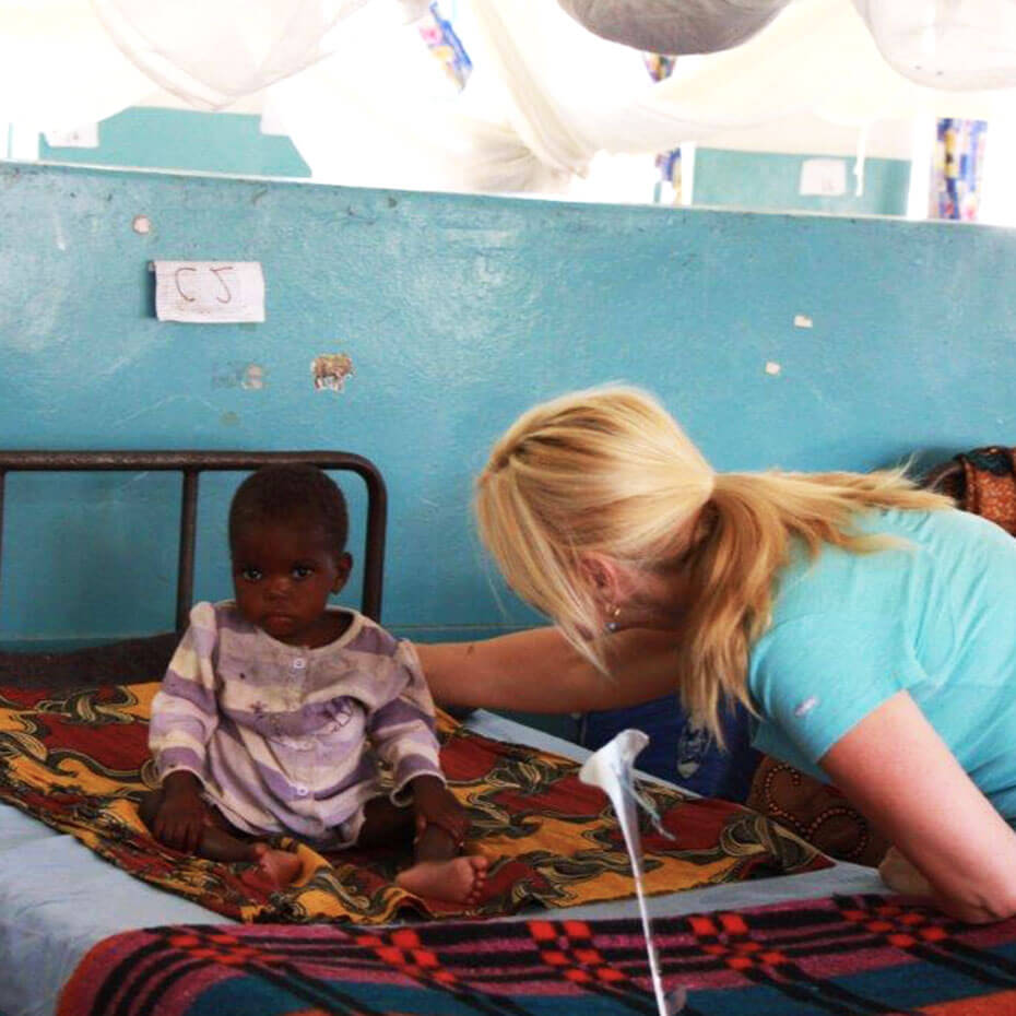 A nurse prays over a child during a mission trip to Kenya.