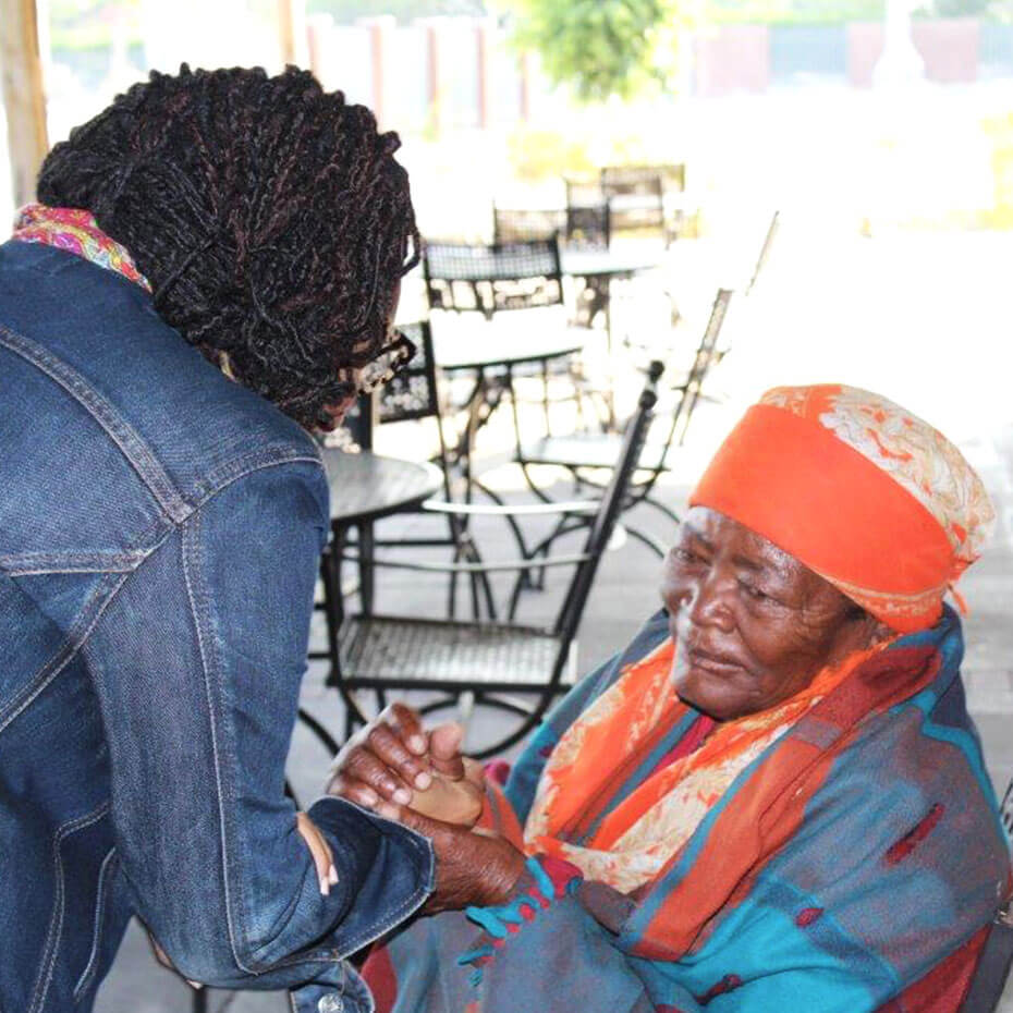 A nurse prays over a woman during a mission trip.