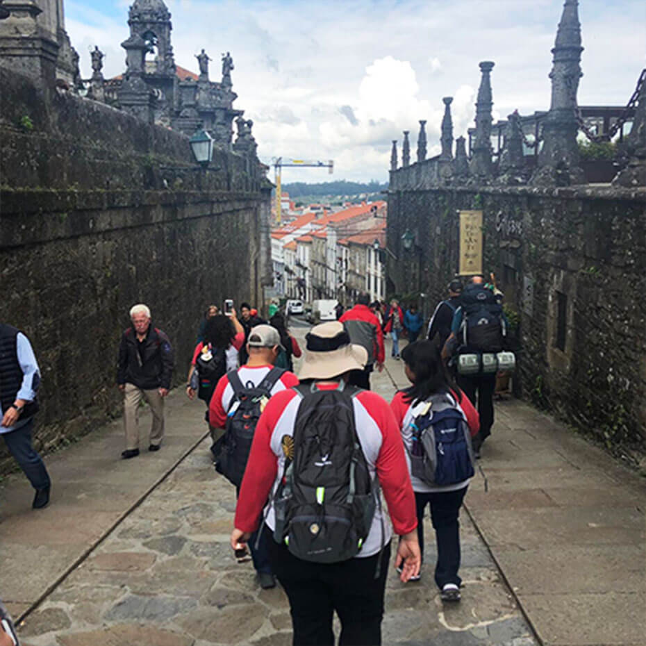 A group of volunteers walks down a stone pathway during a mission trip to Spain.