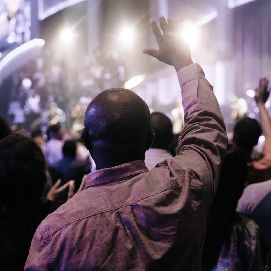 A man raises his hand in worship
